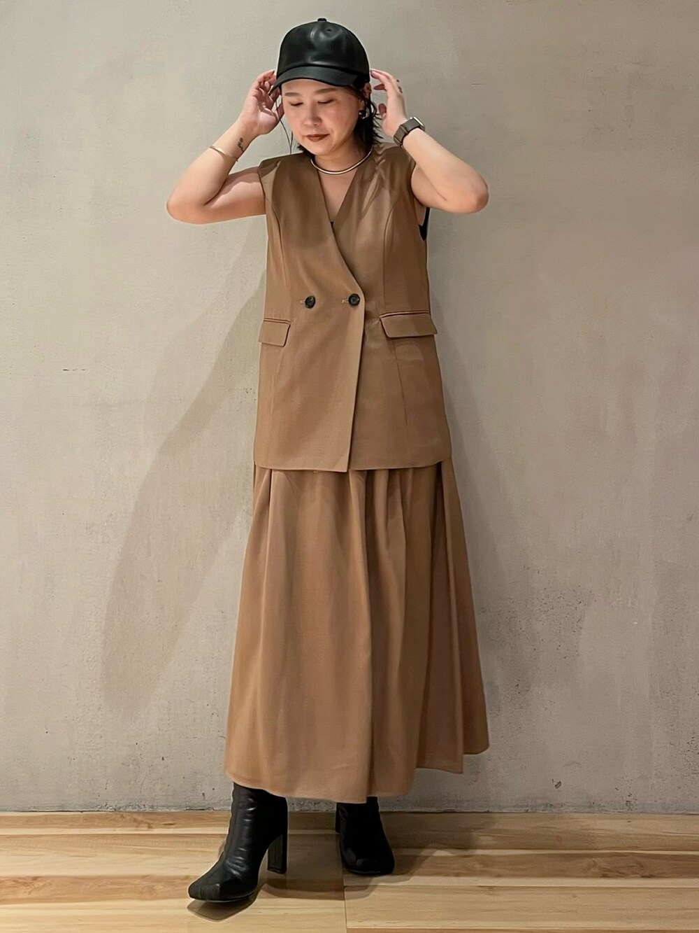 ベージュ系のワンピース、ブラック系のブーツ、ブラック系のキャップを着用したレディースの夏コーディネートの3枚目の写真