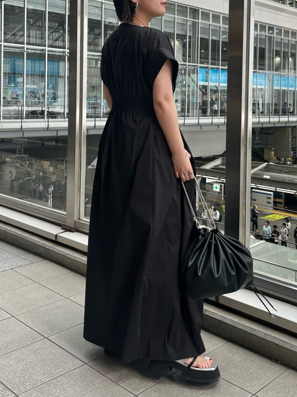 ブラック系のワンピース、ブラック系のショルダーバッグ、その他のサンダルを着用したレディースの春コーディネートの2枚目の写真