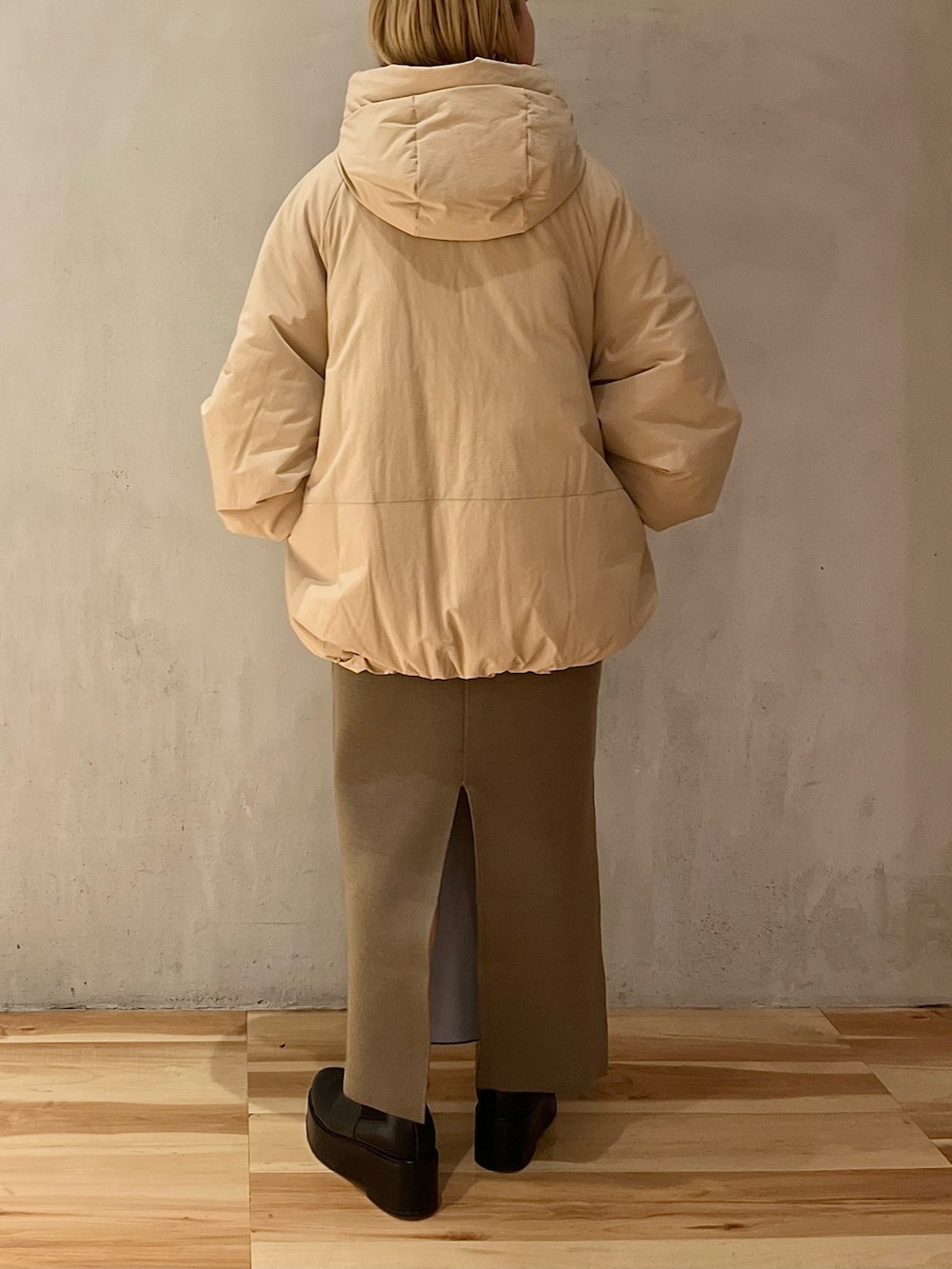 ベージュ系のダウンジャケット/コート、ベージュ系のスカート、ベージュ系のニット/セーターを着用したレディースの冬コーディネートの4枚目の写真