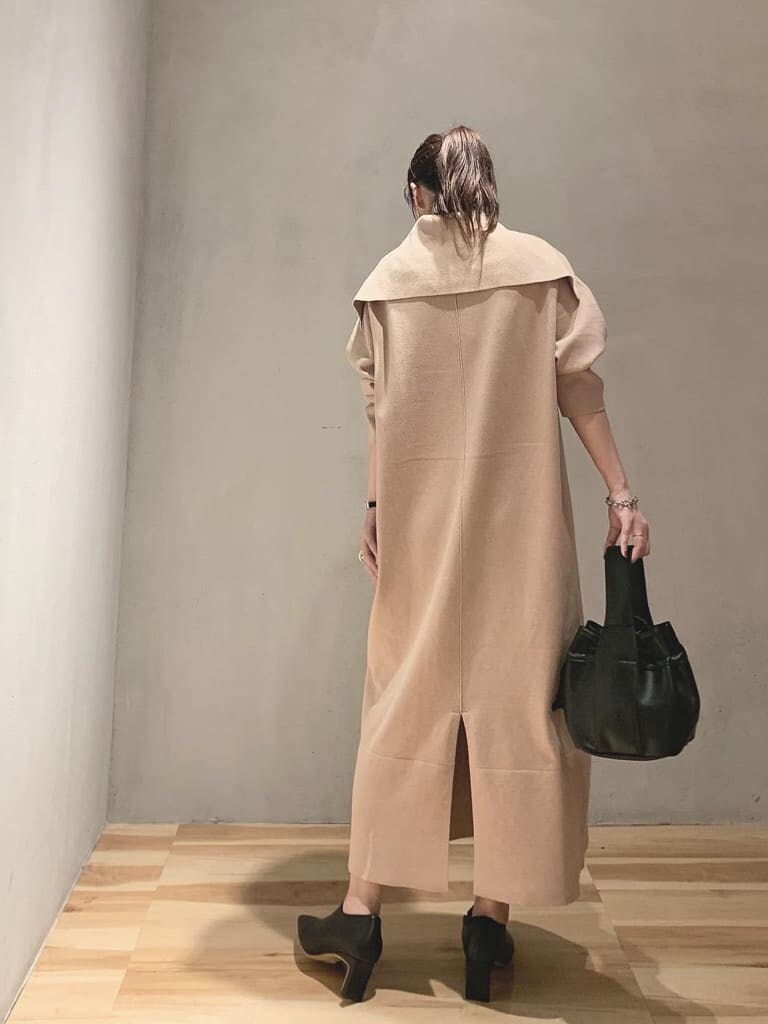 ベージュ系のワンピース、ブラック系のブーツ、ブラック系のハンドバッグを着用したレディースの秋コーディネートの3枚目の写真