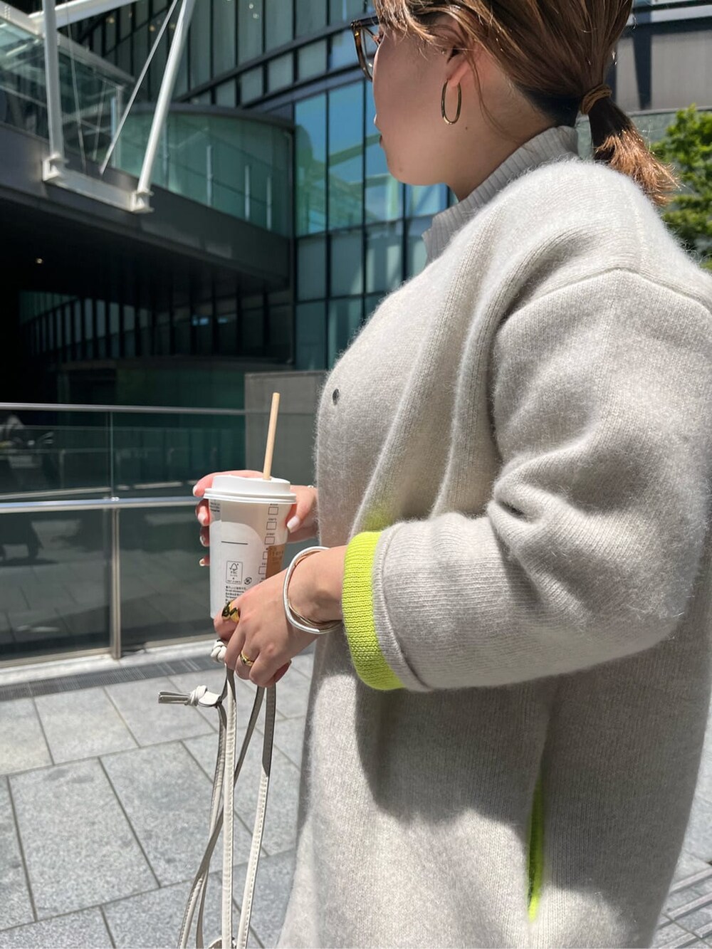 ブラック系のスカート、ホワイト系のニット/セーター、ホワイト系のカーディガン/ボレロを着用したレディースの夏コーディネートの6枚目の写真