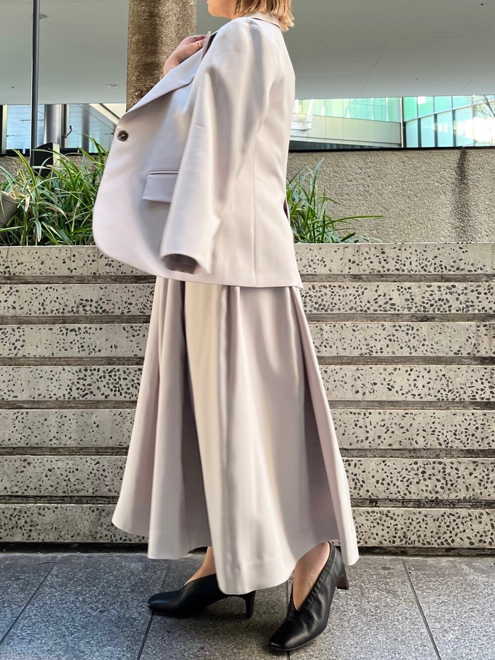 ベージュ系のワンピース、ベージュ系のテーラードジャケット、ブラック系のハンドバッグを着用したレディースの冬コーディネートの2枚目の写真