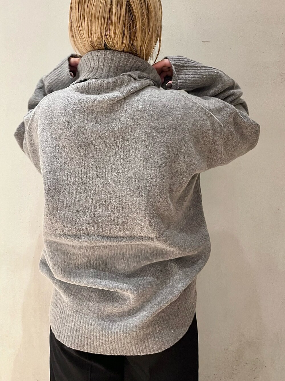 グレー系のニット/セーター、ブラック系のその他パンツ、ブラック系のブーツを着用したレディースの秋コーディネートの8枚目の写真