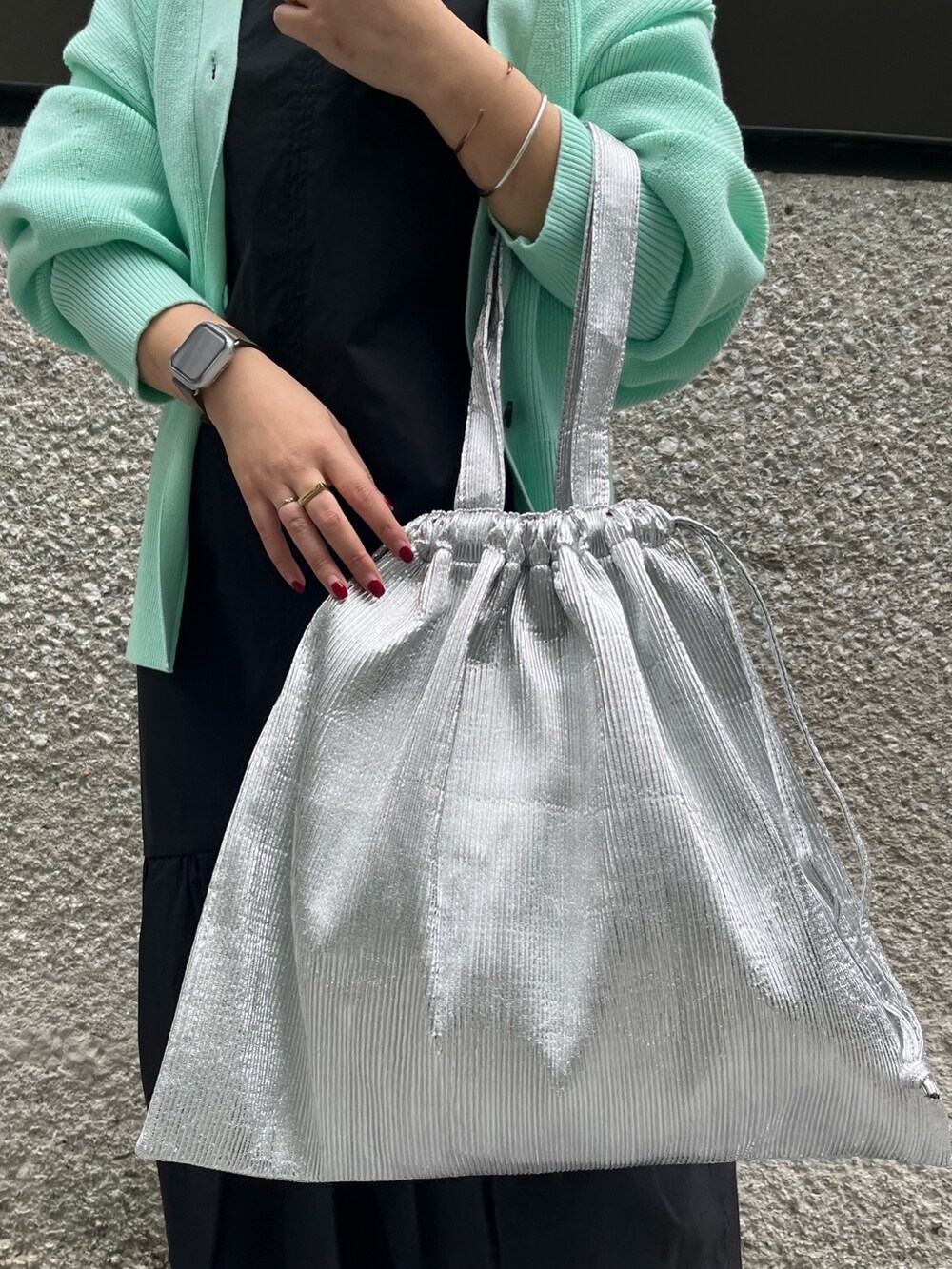 グリーン系のカーディガン/ボレロ、ブルー系のワンピース、シルバー系のトートバッグを着用したレディースの冬コーディネートの7枚目の写真