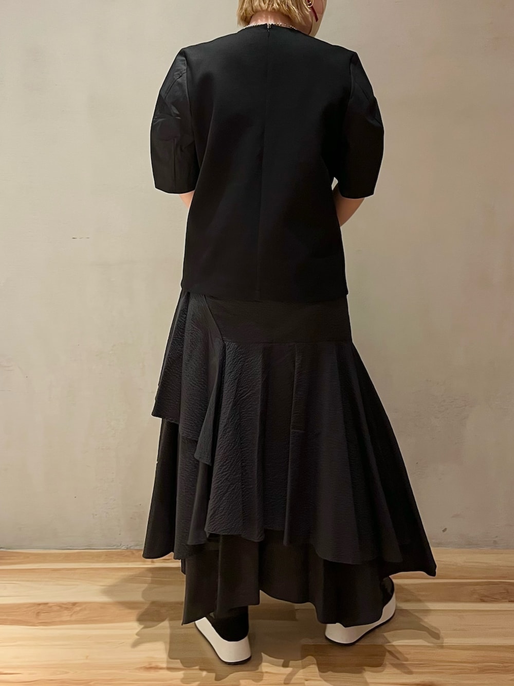 ブラック系のTシャツ/カットソー、ブラック系のスカート、ブラック系のハンドバッグを着用したレディースの春コーディネートの3枚目の写真