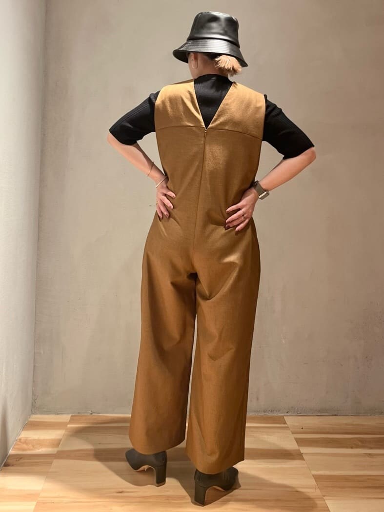 ブラック系のニット/セーター、ブラウン系のつなぎ/オールインワン、ブラック系のブーツを着用したレディースの夏コーディネートの2枚目の写真