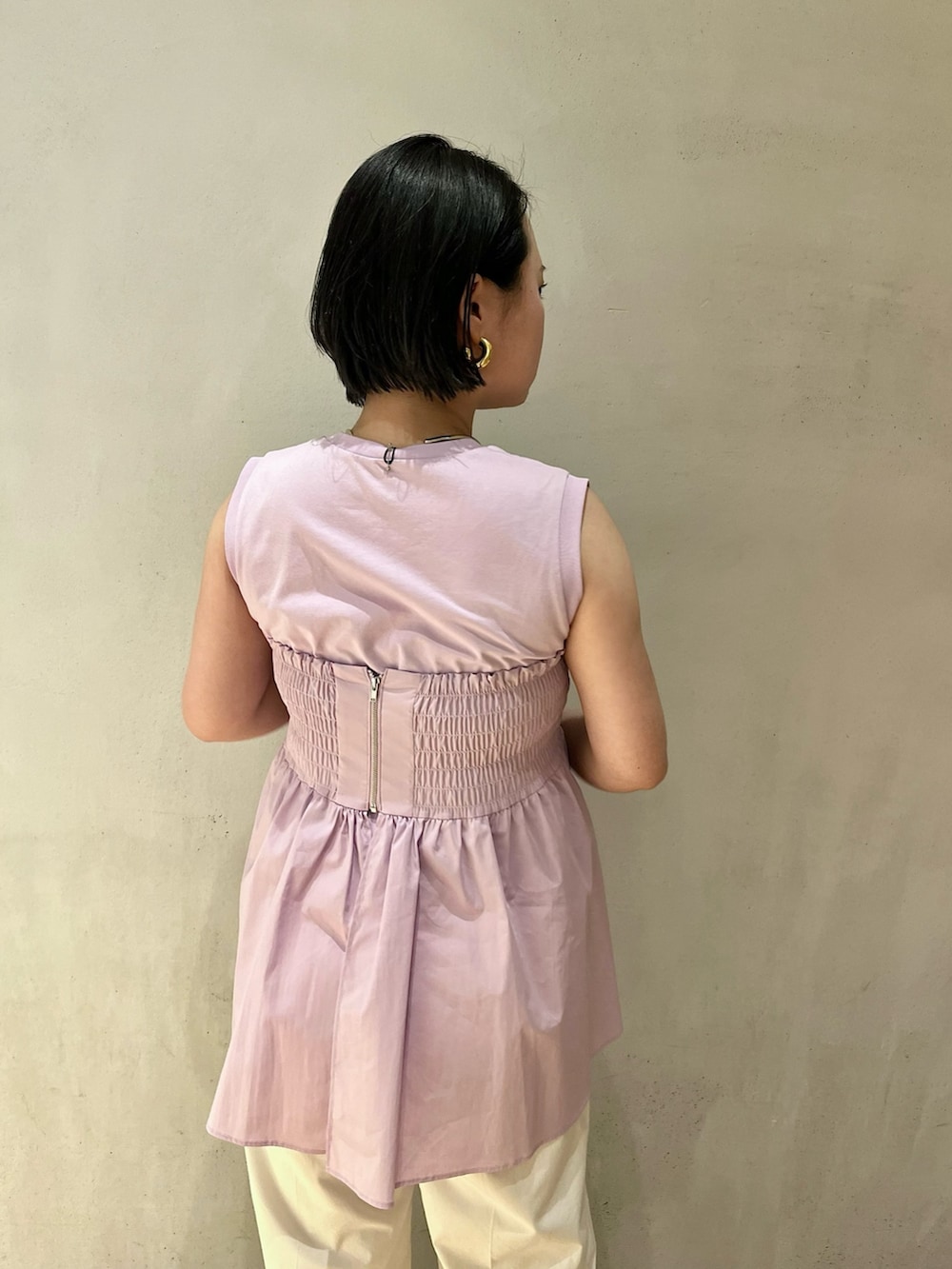 パープル系のタンクトップ、シルバー系のパンプス、ホワイト系のその他パンツを着用したレディースの冬コーディネートの6枚目の写真