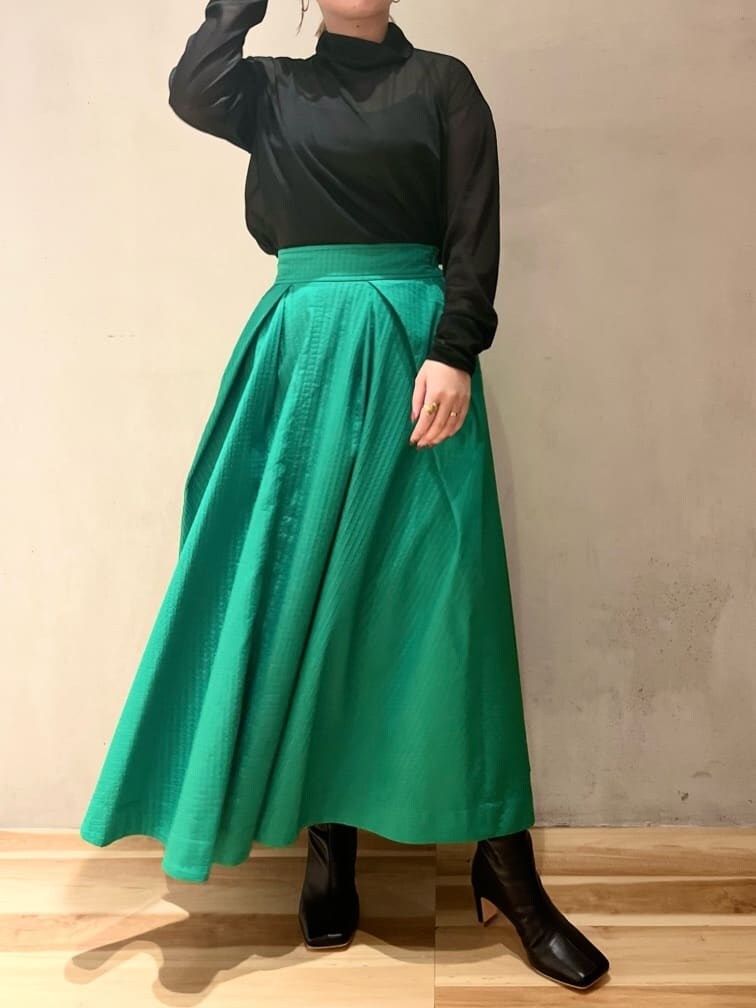 グリーン系のスカート、ブラック系のブーツ、ブラック系のTシャツ/カットソーを着用したレディースの夏コーディネートの4枚目の写真