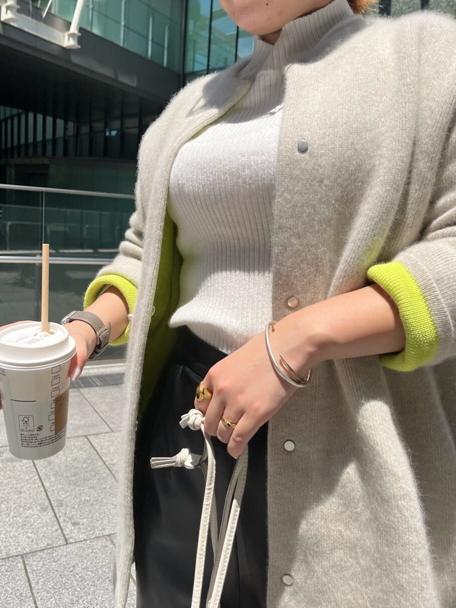 ブラック系のスカート、ホワイト系のニット/セーター、ホワイト系のカーディガン/ボレロを着用したレディースの夏コーディネートの7枚目の写真