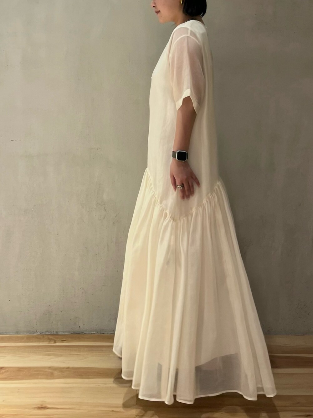 ホワイト系のワンピース、ブラック系のサンダルを着用したレディースの夏コーディネートの3枚目の写真