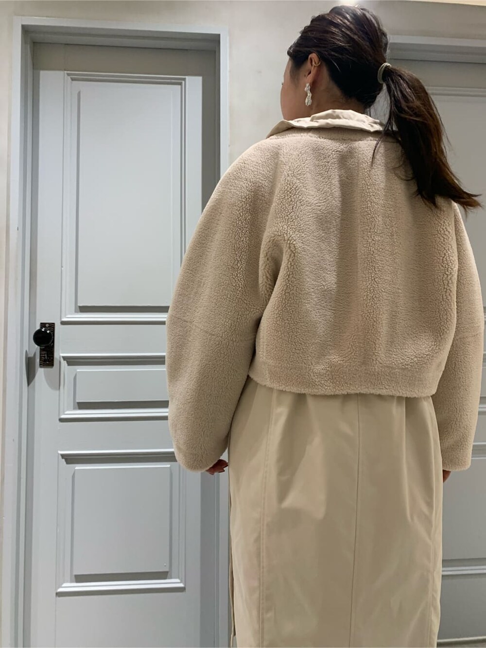 ホワイト系のモッズコート、ブラック系のワンピースを着用したレディースの冬コーディネートの4枚目の写真