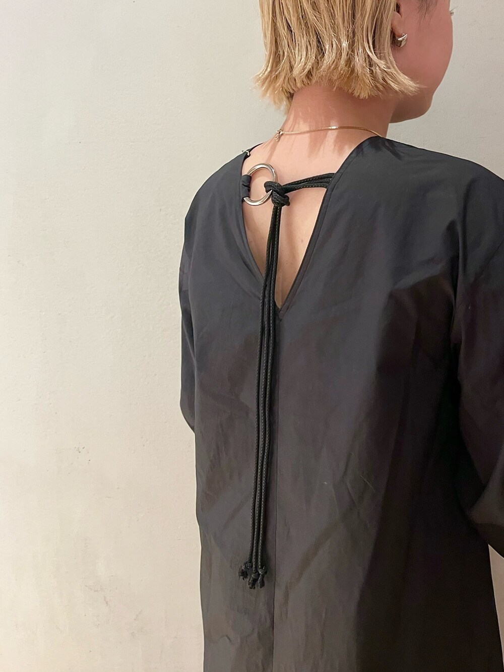 ブラック系のワンピース、ブラック系のブーツを着用したレディースの春コーディネートの4枚目の写真