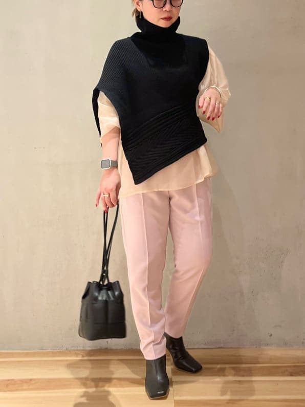 ブラック系のブーツ、ベージュ系のニット/セーター、ブラック系のワンピースを着用したレディースの秋コーディネートの3枚目の写真