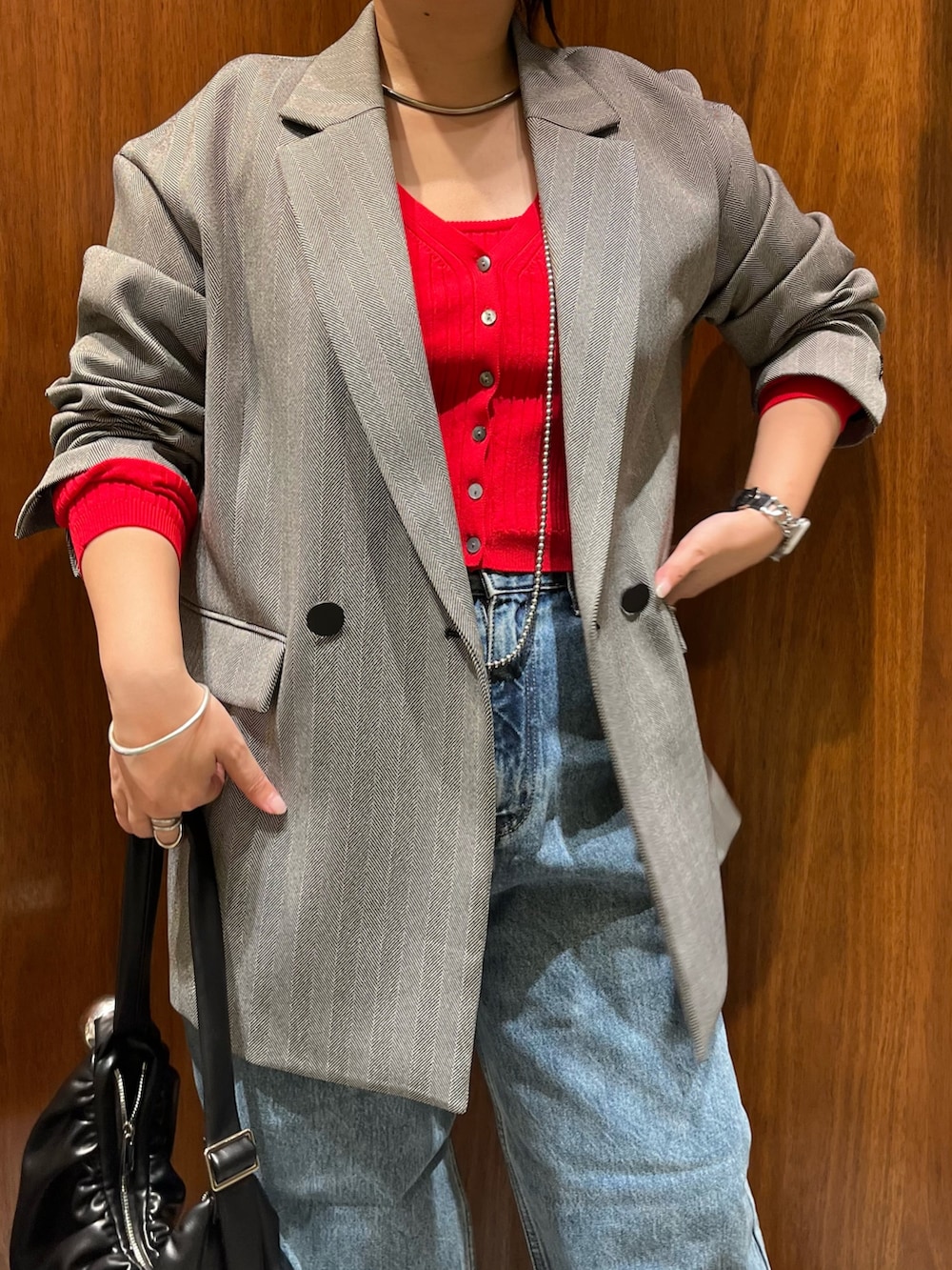 ブラック系のテーラードジャケット、レッド系のカーディガン/ボレロ、ブラック系のハンドバッグを着用したレディースの秋コーディネートの5枚目の写真