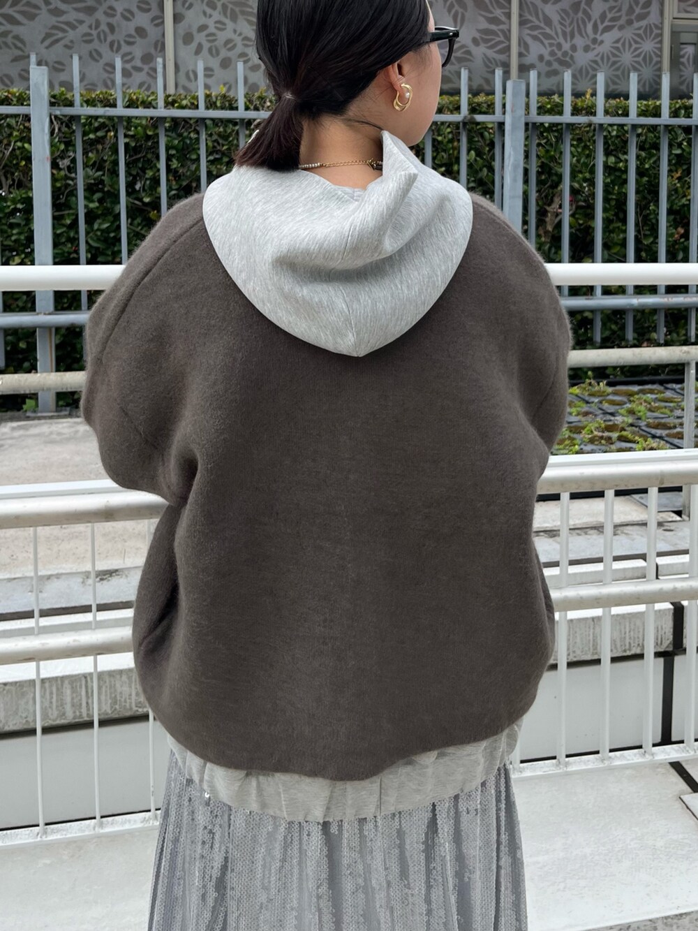 ブラウン系のカーディガン/ボレロ、グレー系のワンピース、ブラック系のブーツを着用したレディースの秋コーディネートの6枚目の写真