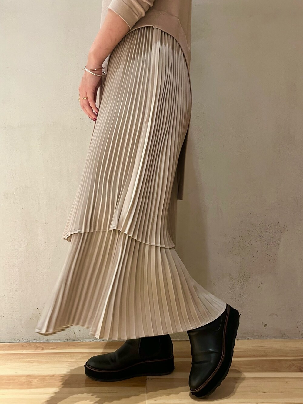 グリーン系のチェスターコート、ブラック系のカーディガン/ボレロ、ベージュ系のワンピースを着用したレディースの冬コーディネートの9枚目の写真