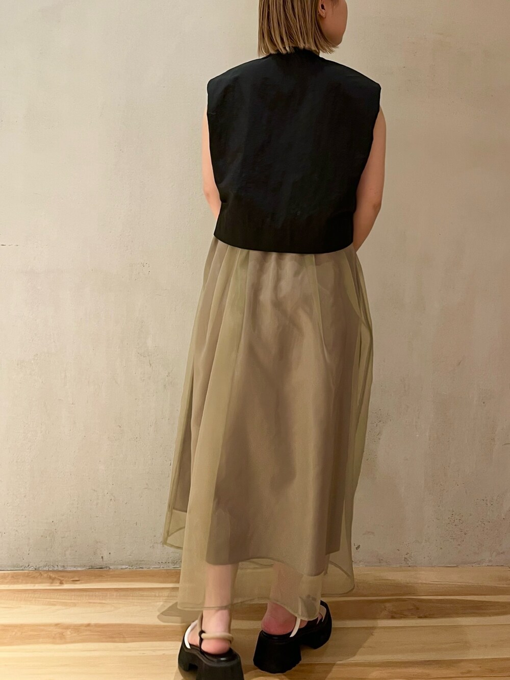 ブラック系のシャツ/ブラウス、ブラウン系のスカート、その他のサンダルを着用したレディースの冬コーディネートの3枚目の写真