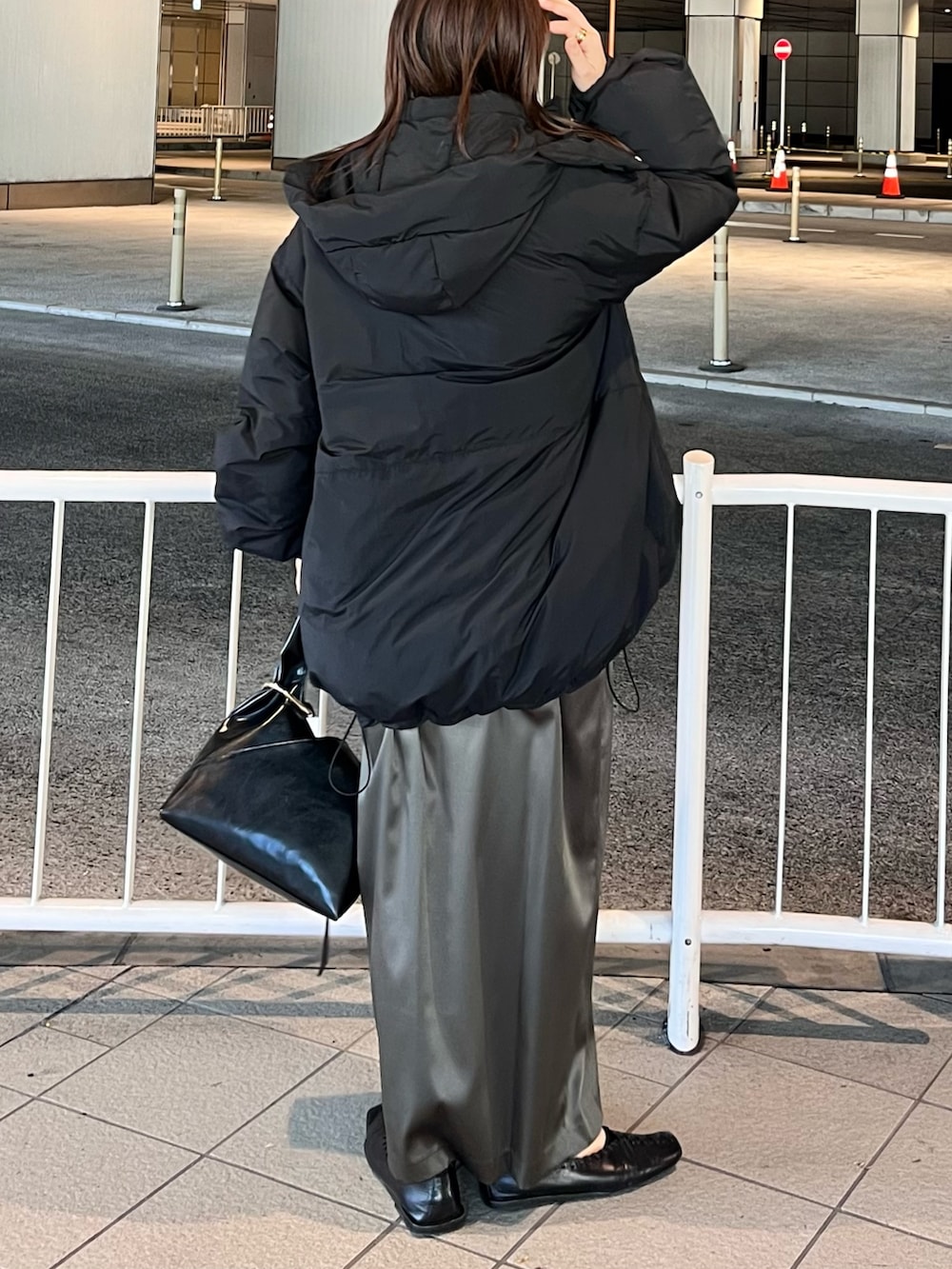 ブラック系のダウンジャケット/コート、ブラウン系のニット/セーター、ブラウン系のスカートを着用したレディースの冬コーディネートの2枚目の写真