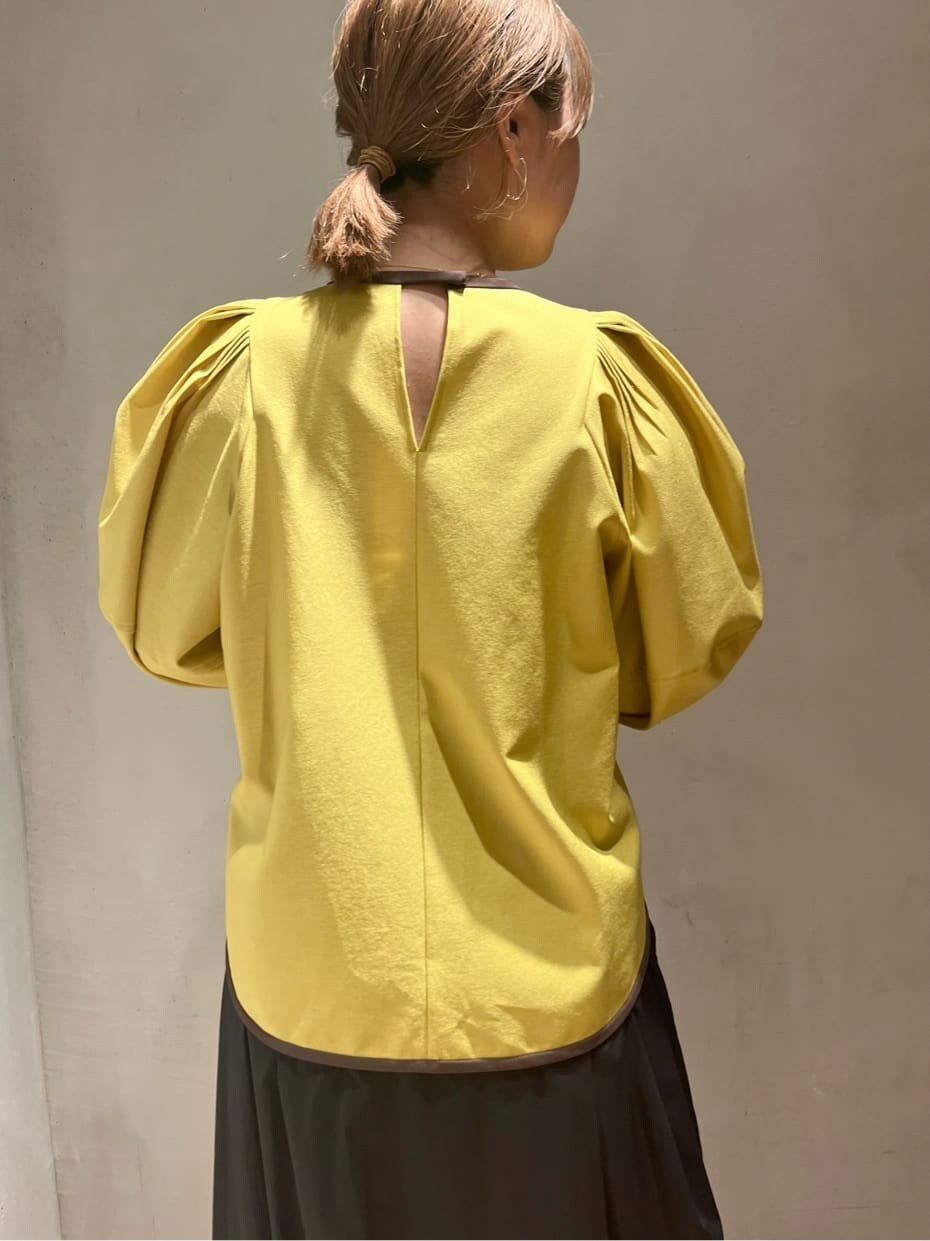 イエロー系のシャツ/ブラウス、ブラック系のスカート、ブラック系のブーツを着用したレディースの夏コーディネートの5枚目の写真