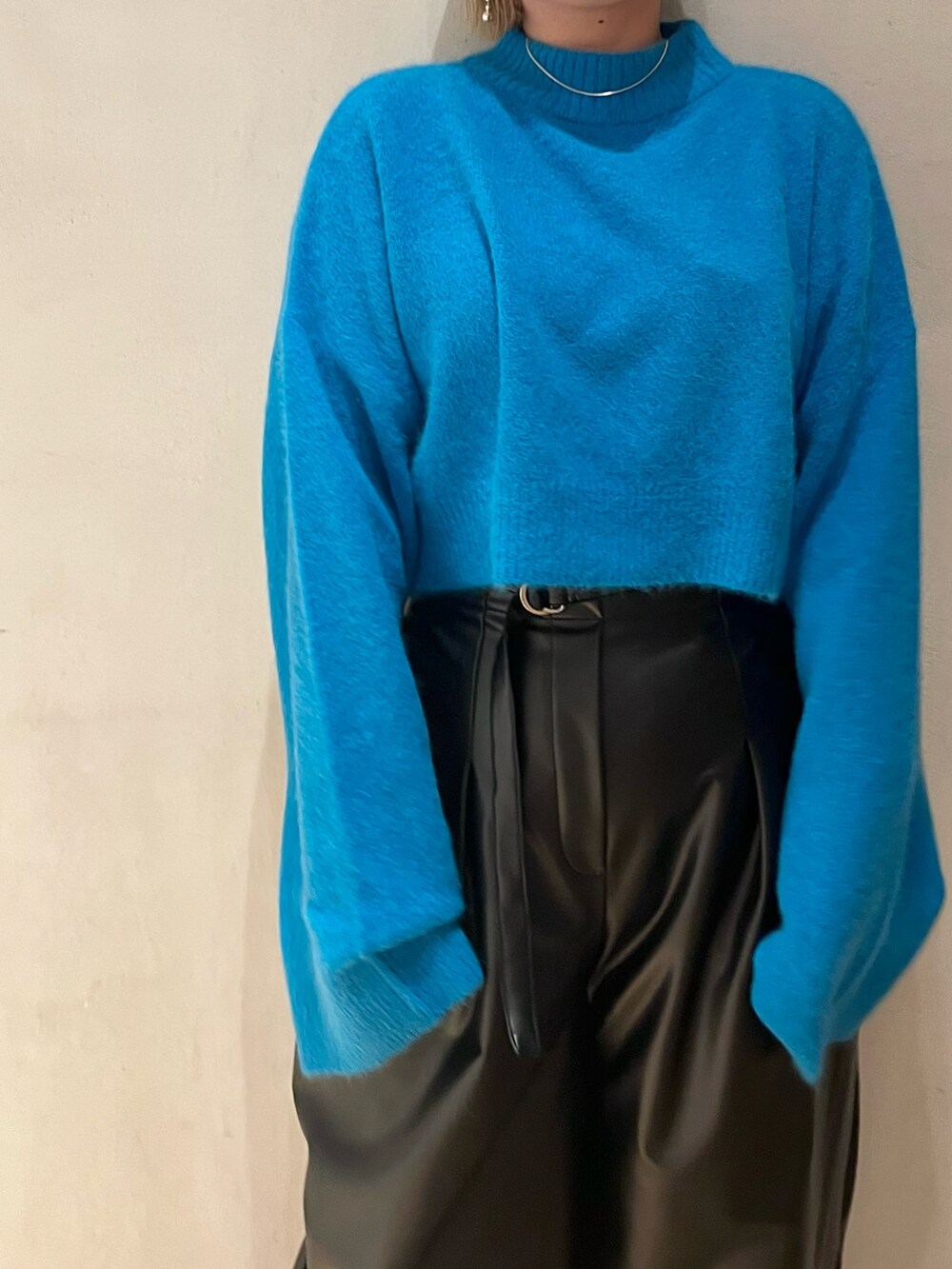 ブルー系のニット/セーター、ブラック系のその他パンツ、ブラック系のブーツを着用したレディースの秋コーディネートの5枚目の写真