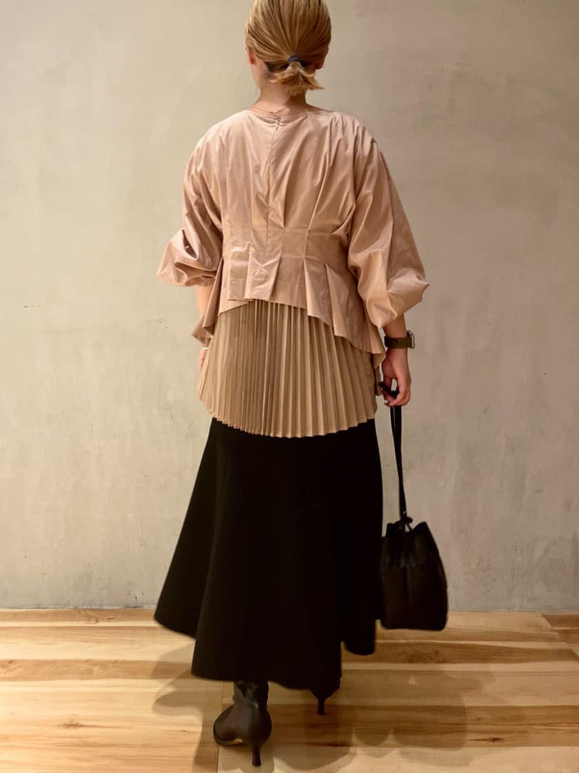 ブラック系のスカート、ベージュ系のシャツ/ブラウスを着用したレディースの秋コーディネートの2枚目の写真