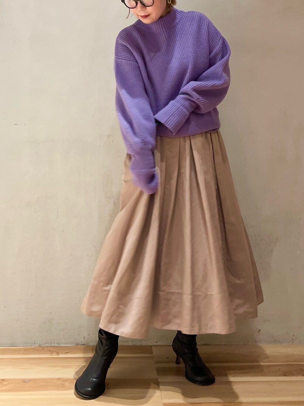 パープル系のニット/セーター、ベージュ系のスカート、パープル系のストール/ショールを着用したレディースの冬コーディネートの4枚目の写真
