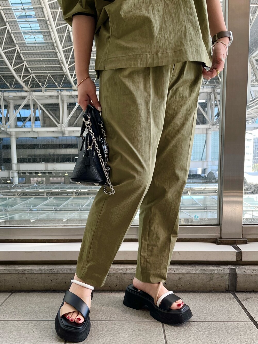 グリーン系のブルゾン、グリーン系のその他パンツ、その他のサンダルを着用したレディースの春コーディネートの7枚目の写真