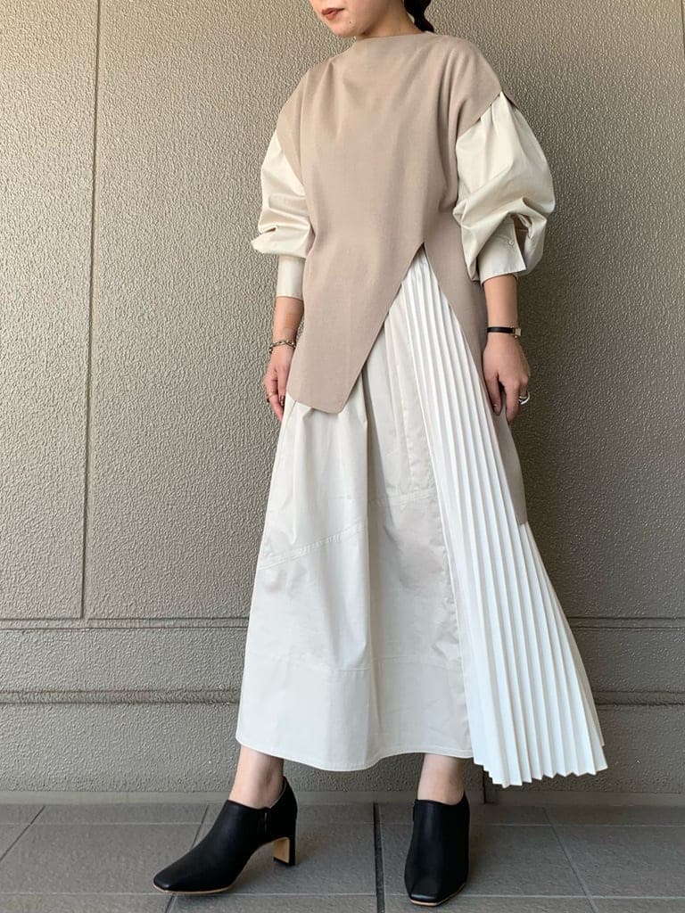 ベージュ系のワンピース、ブラック系のブーツを着用したレディースの秋コーディネートの2枚目の写真