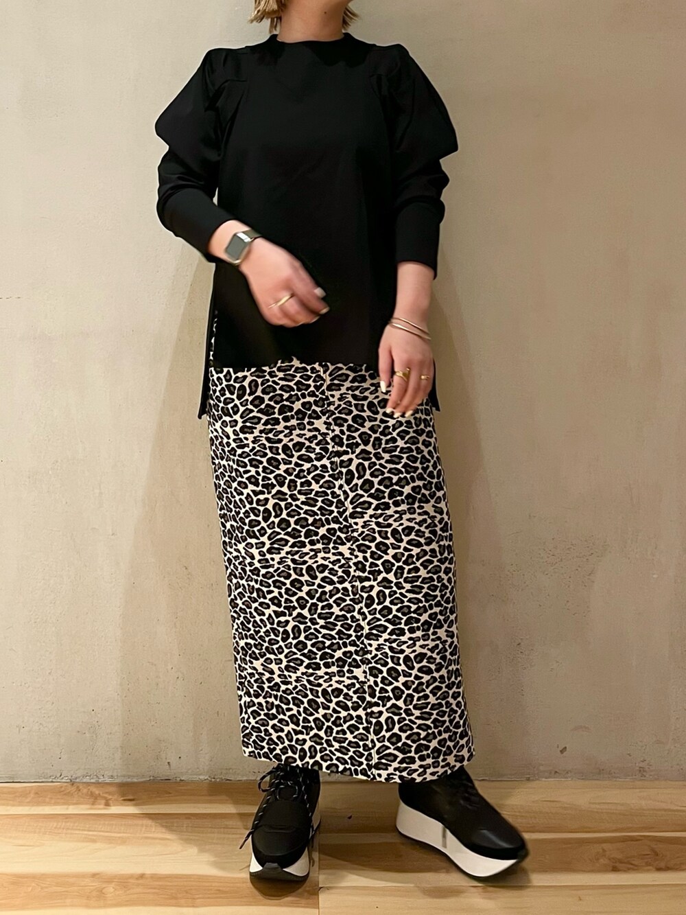 ブラック系のTシャツ/カットソー、ホワイト系のスカート、ブラック系のスニーカーを着用したレディースの春コーディネートの4枚目の写真