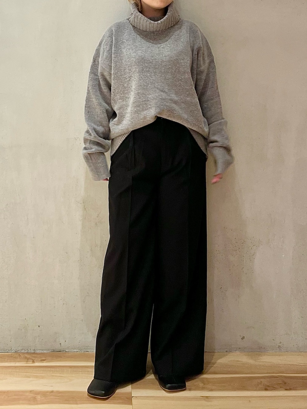 グレー系のニット/セーター、ブラック系のその他パンツ、ブラック系のブーツを着用したレディースの秋コーディネートの3枚目の写真