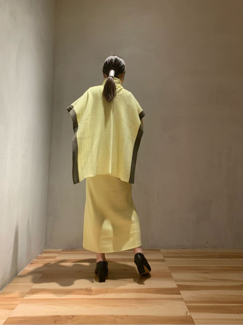 イエロー系のワンピース、ブラック系のブーツを着用したレディースの秋コーディネートの4枚目の写真