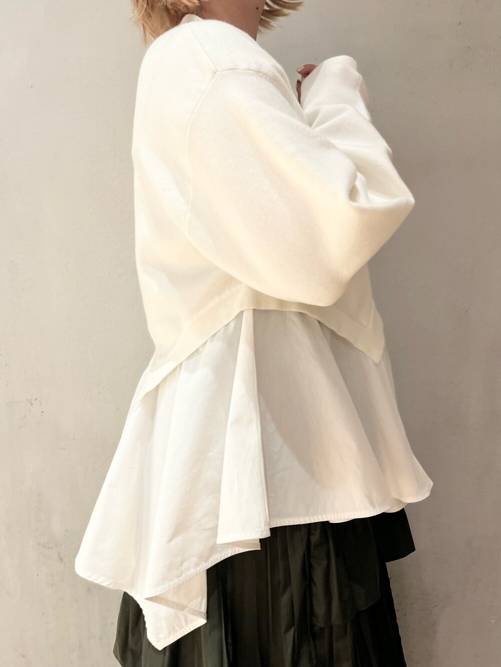 ホワイト系のニット/セーター、ベージュ系のスカート、ブルー系のスニーカーを着用したレディースの秋コーディネートの6枚目の写真