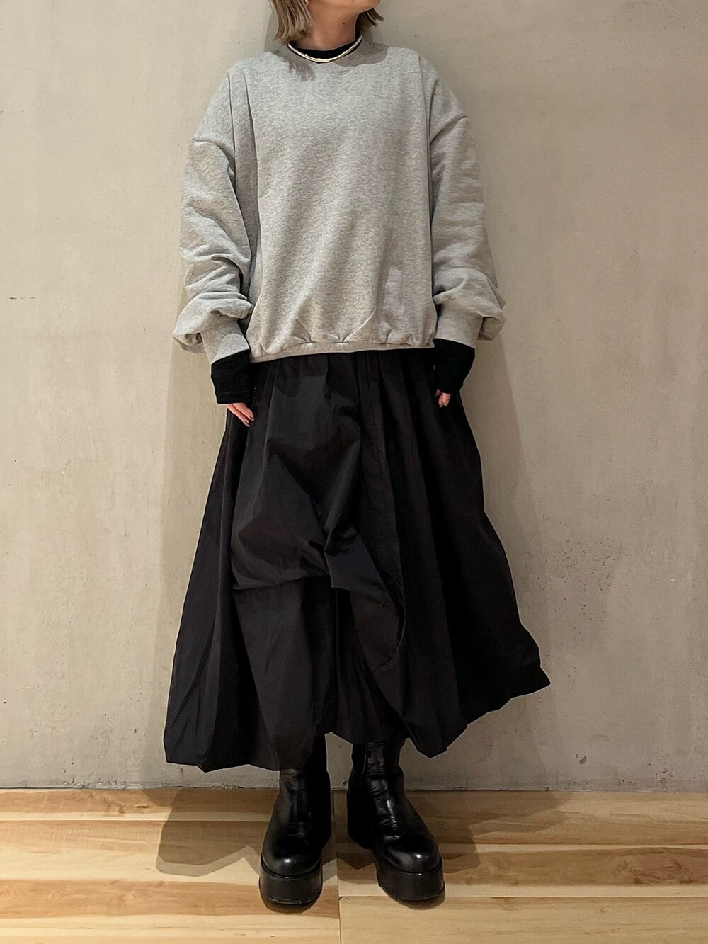 グレー系のスウェット、ブラック系のTシャツ/カットソー、ブラック系のスカートを着用したレディースの冬コーディネートの2枚目の写真