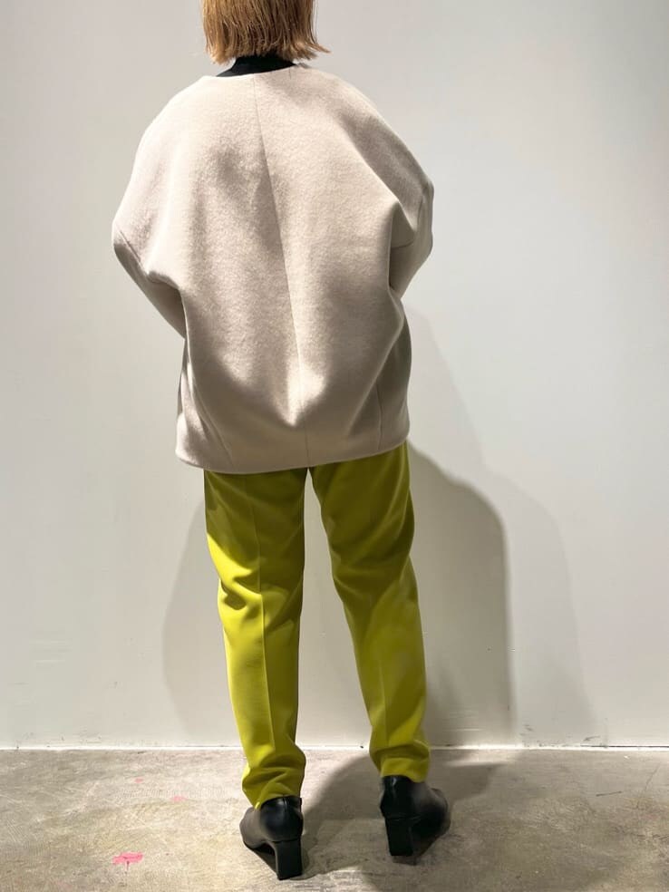 ブラック系のショルダーバッグ、グリーン系のその他パンツ、ベージュ系のノーカラーコートを着用したレディースの秋コーディネートの3枚目の写真