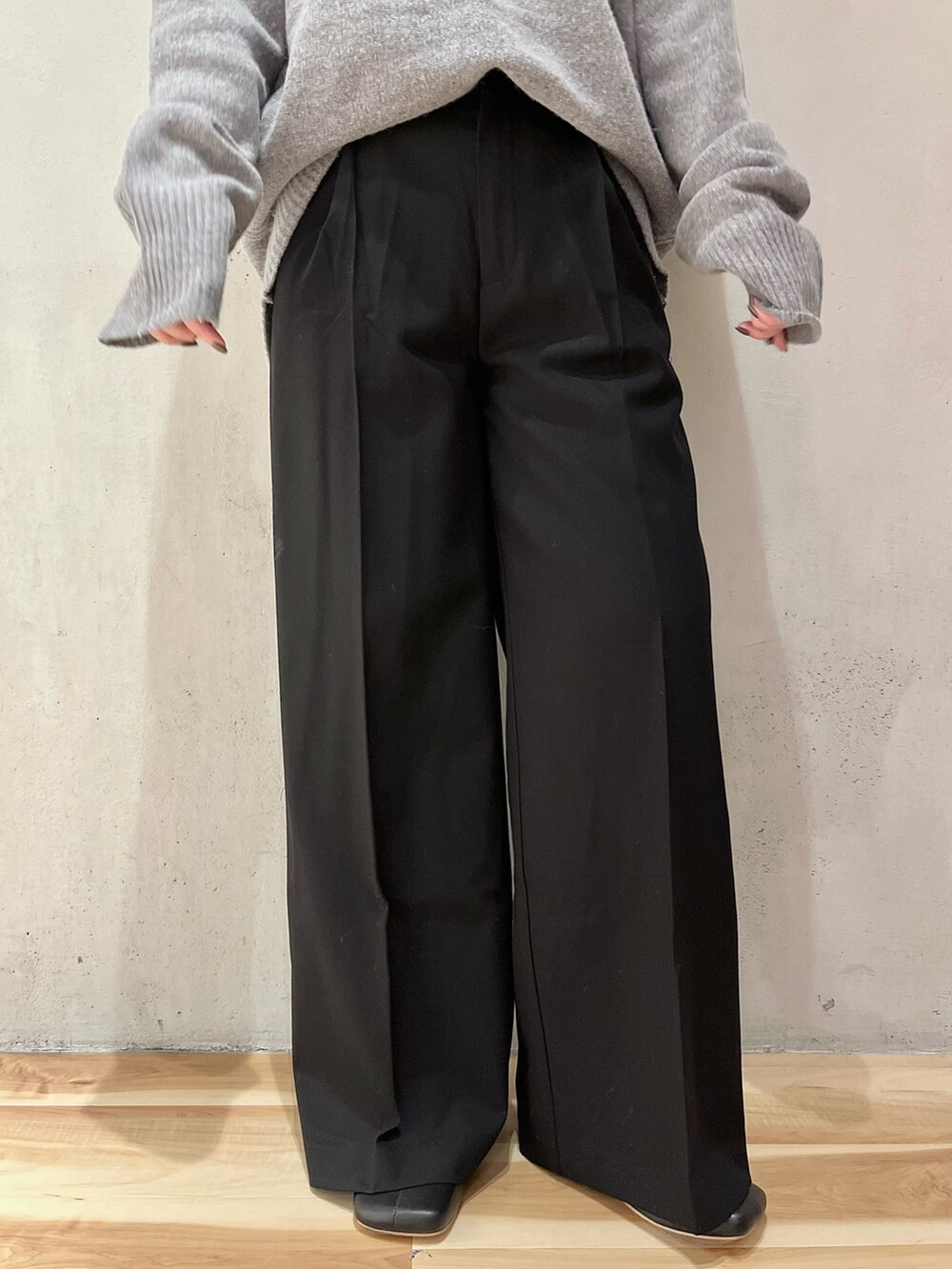 グレー系のニット/セーター、ブラック系のその他パンツ、ブラック系のブーツを着用したレディースの秋コーディネートの9枚目の写真