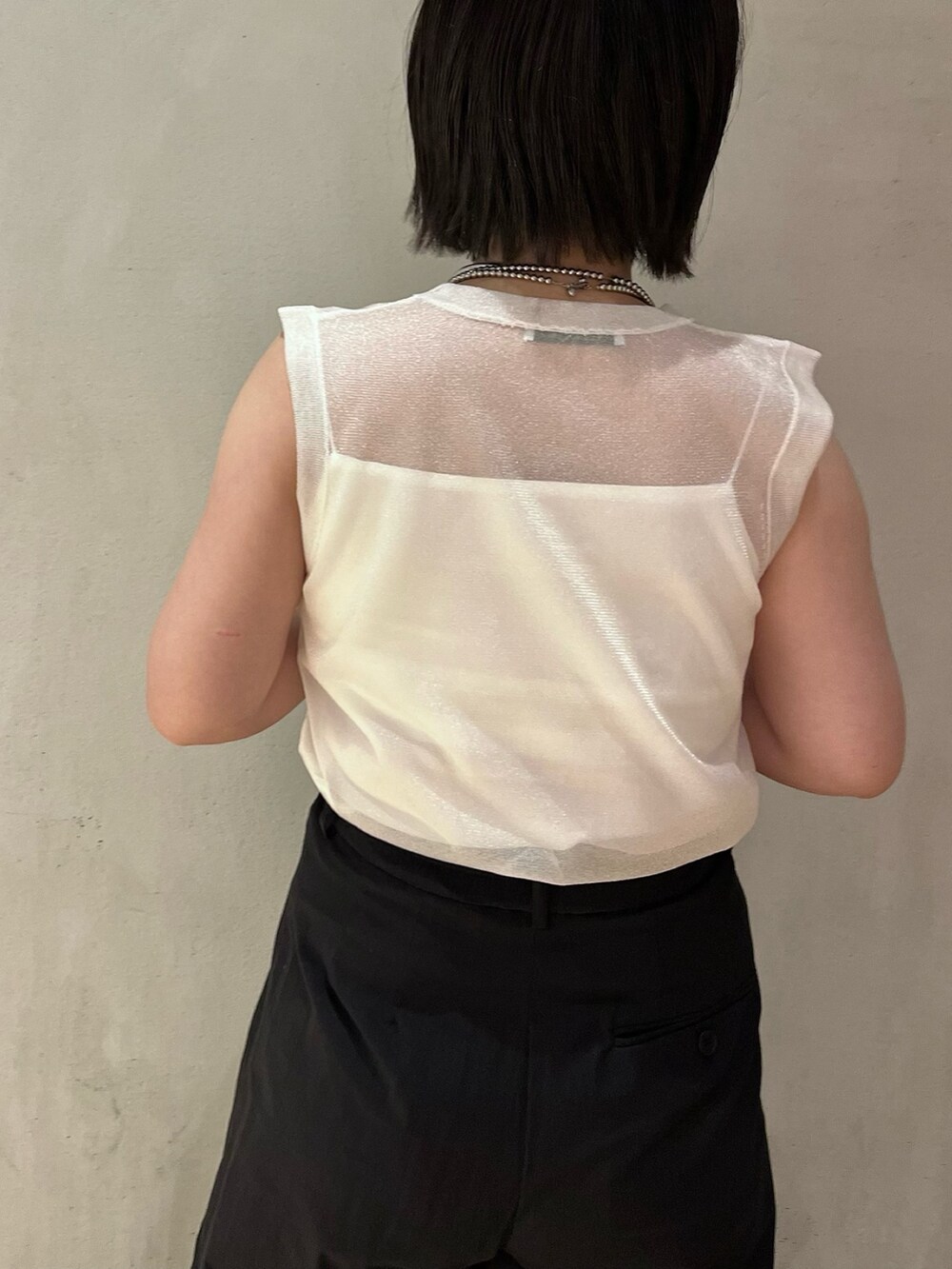 ホワイト系のタンクトップ、ブラック系のその他パンツ、ブラック系のサンダルを着用したレディースの春コーディネートの6枚目の写真