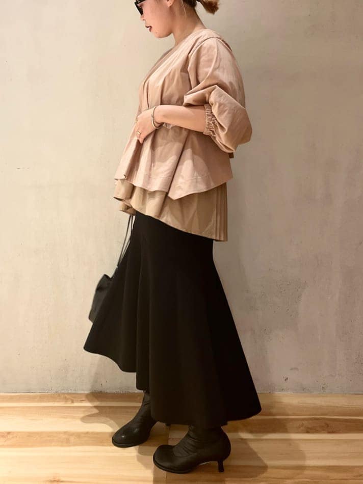 ブラック系のスカート、ベージュ系のシャツ/ブラウスを着用したレディースの秋コーディネートの3枚目の写真