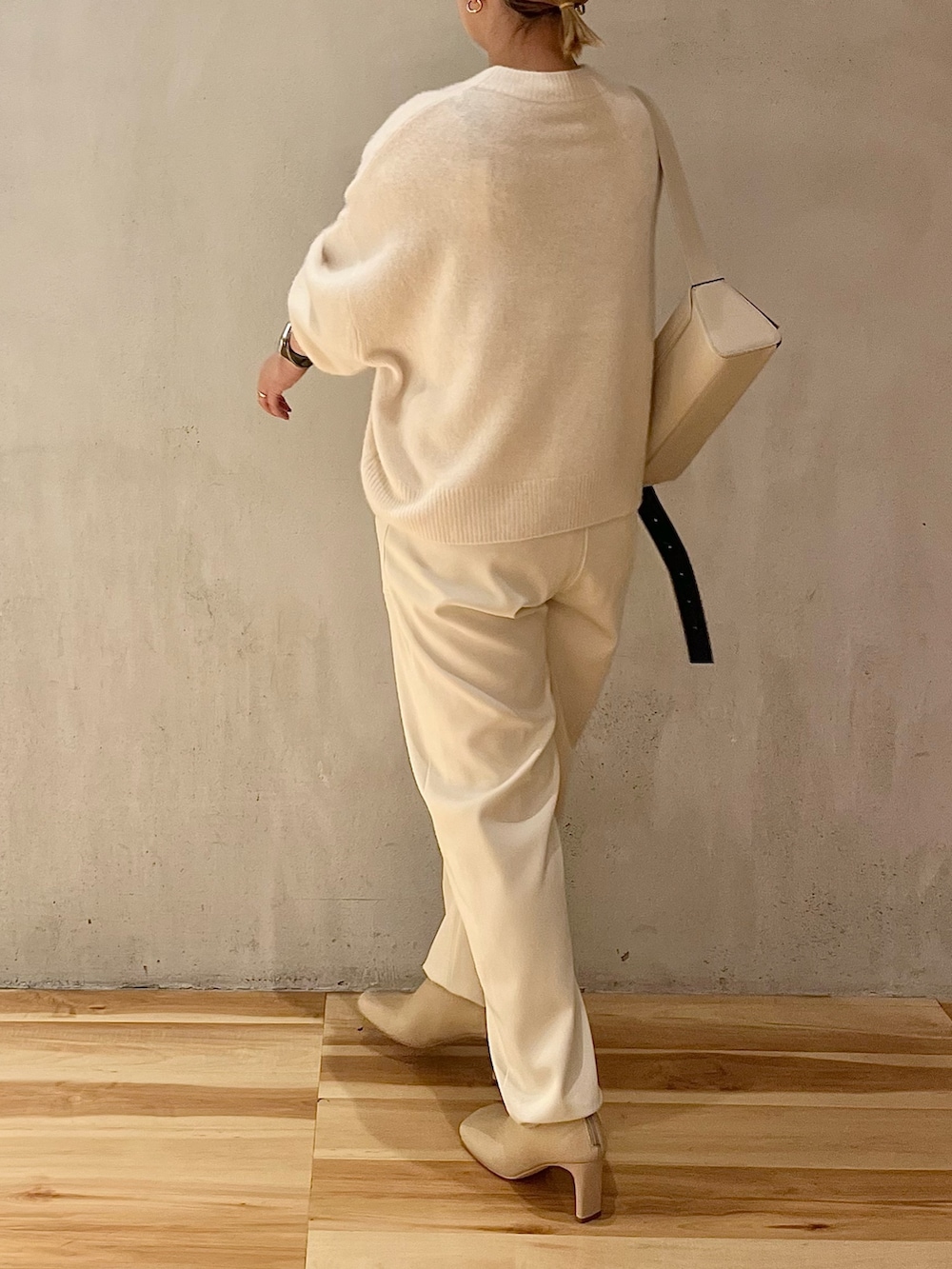 ホワイト系のニット/セーター、ホワイト系のその他パンツ、ベージュ系のブーツを着用したレディースの秋コーディネートの2枚目の写真