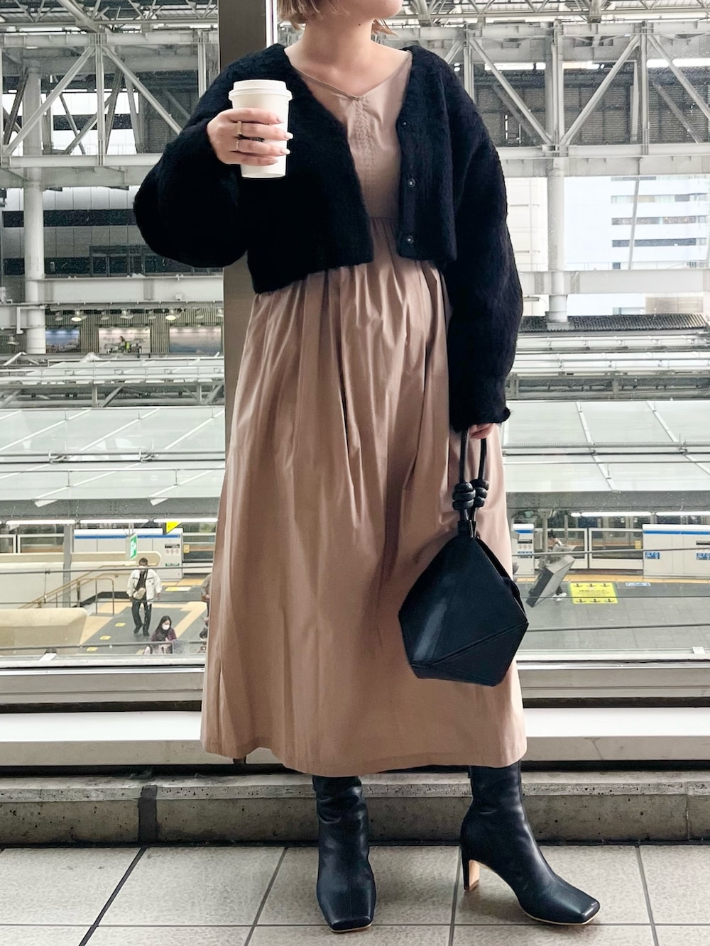 ブラック系のワンピース、ブラック系のハンドバッグ、ブラック系のブーツを着用したレディースの秋コーディネートの4枚目の写真