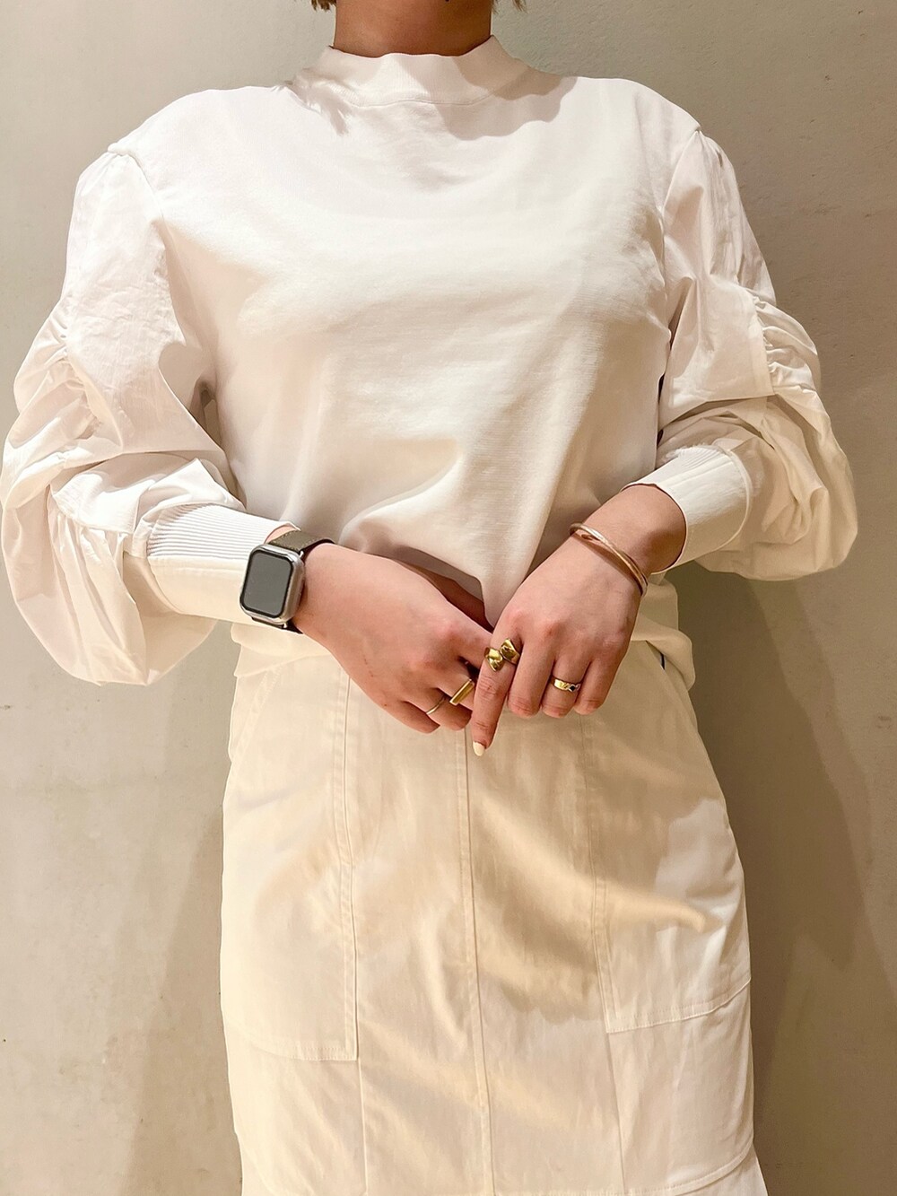 イエロー系のテーラードジャケット、ホワイト系のニット/セーター、ホワイト系のスカートを着用したレディースの冬コーディネートの6枚目の写真