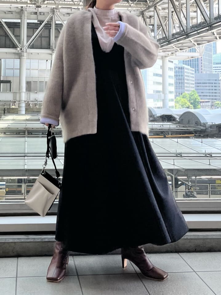 ブラック系のジャンパースカート、ホワイト系のショルダーバッグ、ベージュ系のシャツ/ブラウスを着用したレディースの夏コーディネートの2枚目の写真