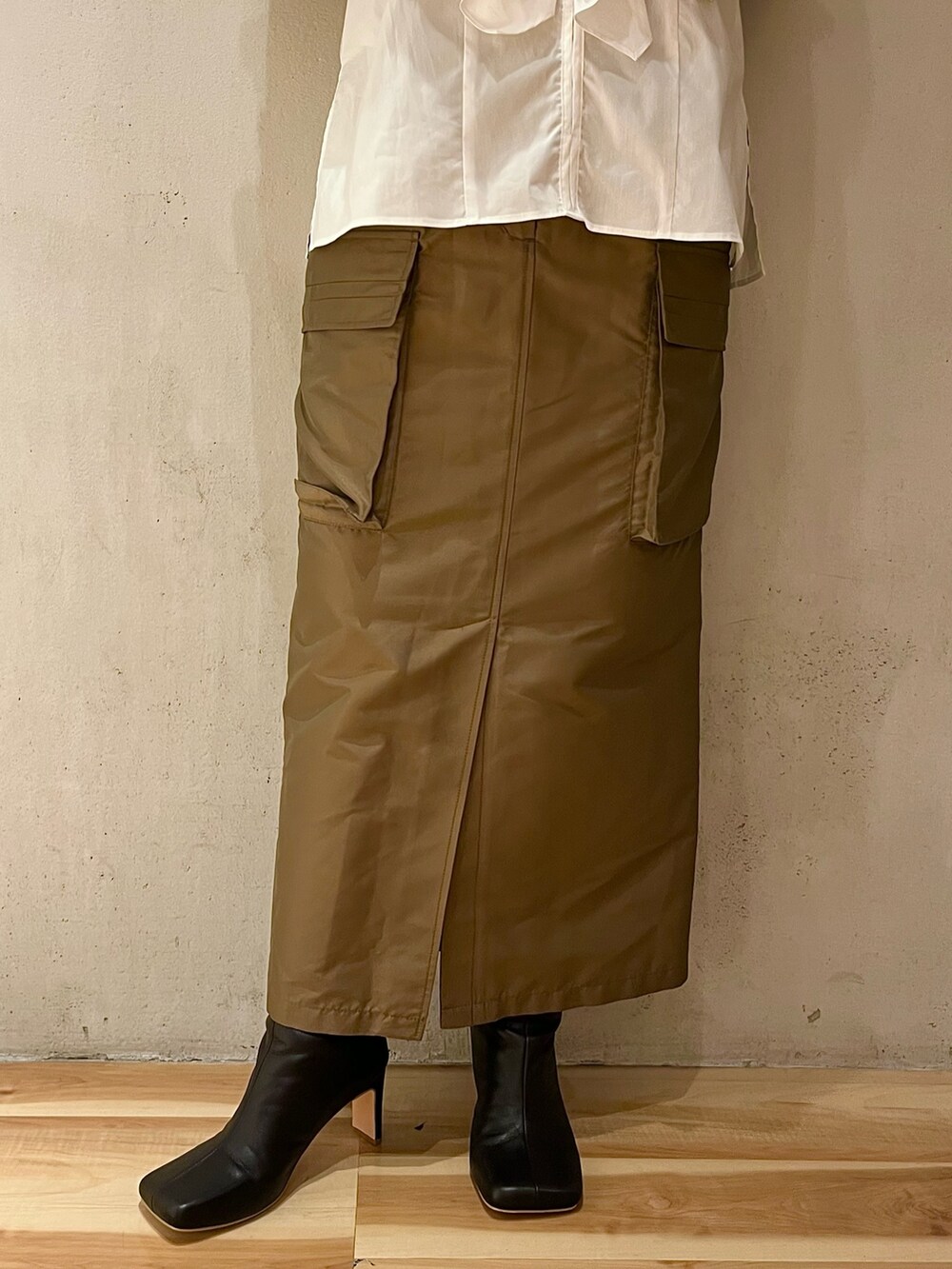 ホワイト系のシャツ/ブラウス、ブラウン系のスカート、ブラック系のブーツを着用したレディースの春コーディネートの8枚目の写真