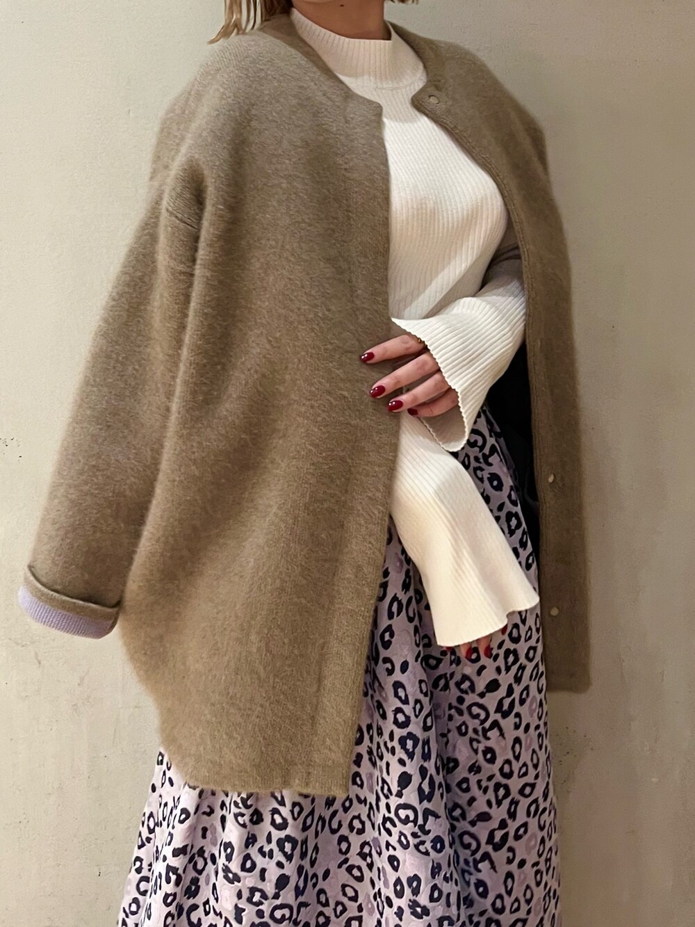 ホワイト系のニット/セーター、パープル系のスカート、ブラウン系のブーツを着用したレディースの冬コーディネートの6枚目の写真