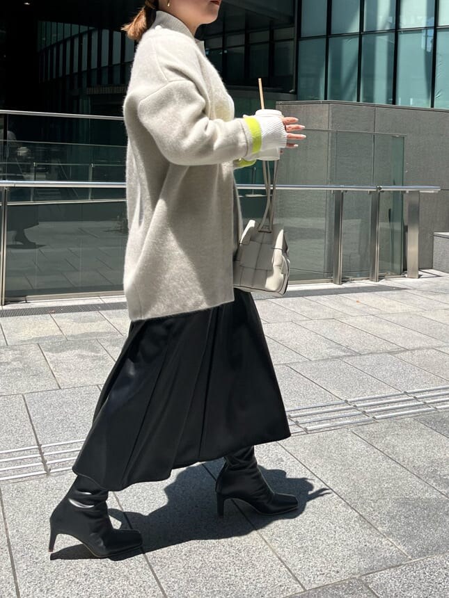 ブラック系のスカート、ホワイト系のニット/セーター、ホワイト系のカーディガン/ボレロを着用したレディースの夏コーディネートの2枚目の写真