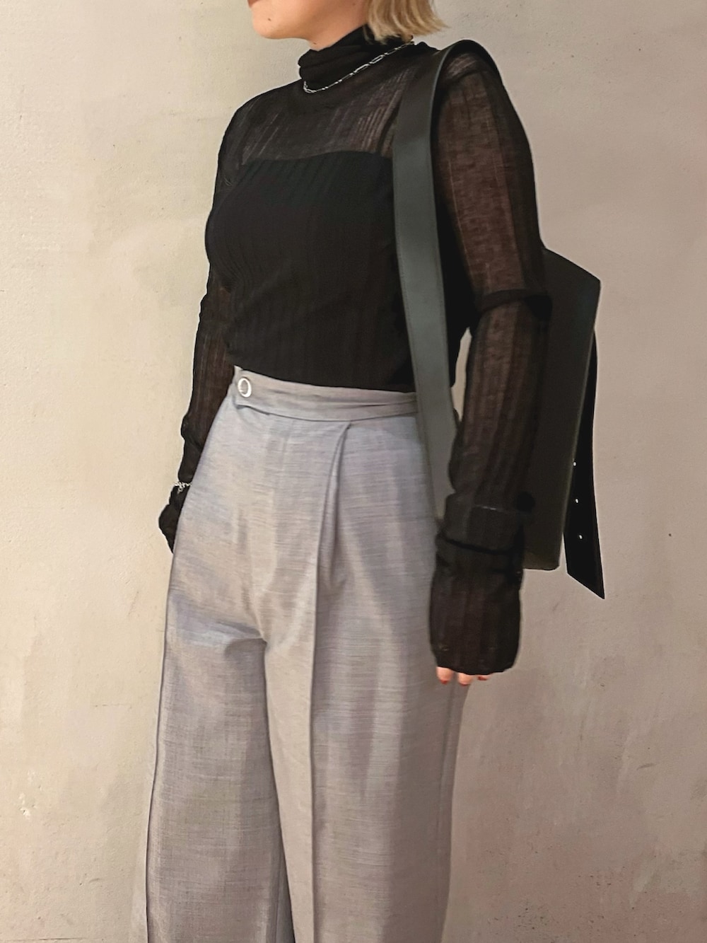ブラック系のニット/セーター、グレー系のその他パンツ、ブラック系のショルダーバッグを着用したレディースの秋コーディネートの5枚目の写真