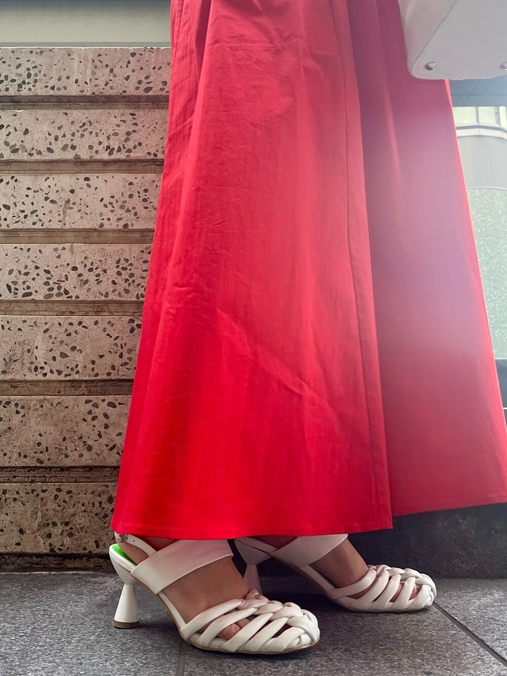 レッド系のワンピース、ホワイト系のハンドバッグ、ホワイト系のサンダルを着用したレディースの冬コーディネートの8枚目の写真