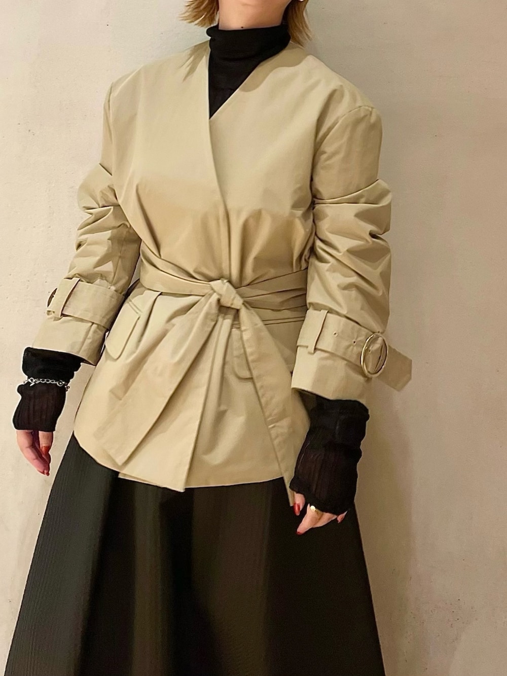 ベージュ系のノーカラージャケット、ブラック系のニット/セーター、ブラック系のスカートを着用したレディースの秋コーディネートの4枚目の写真