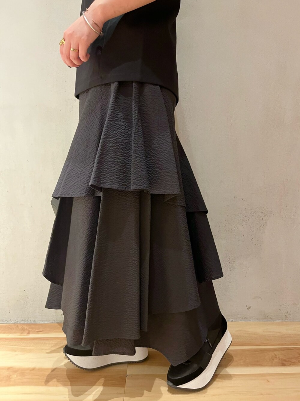 ブラック系のTシャツ/カットソー、ブラック系のスカート、ブラック系のハンドバッグを着用したレディースの春コーディネートの7枚目の写真