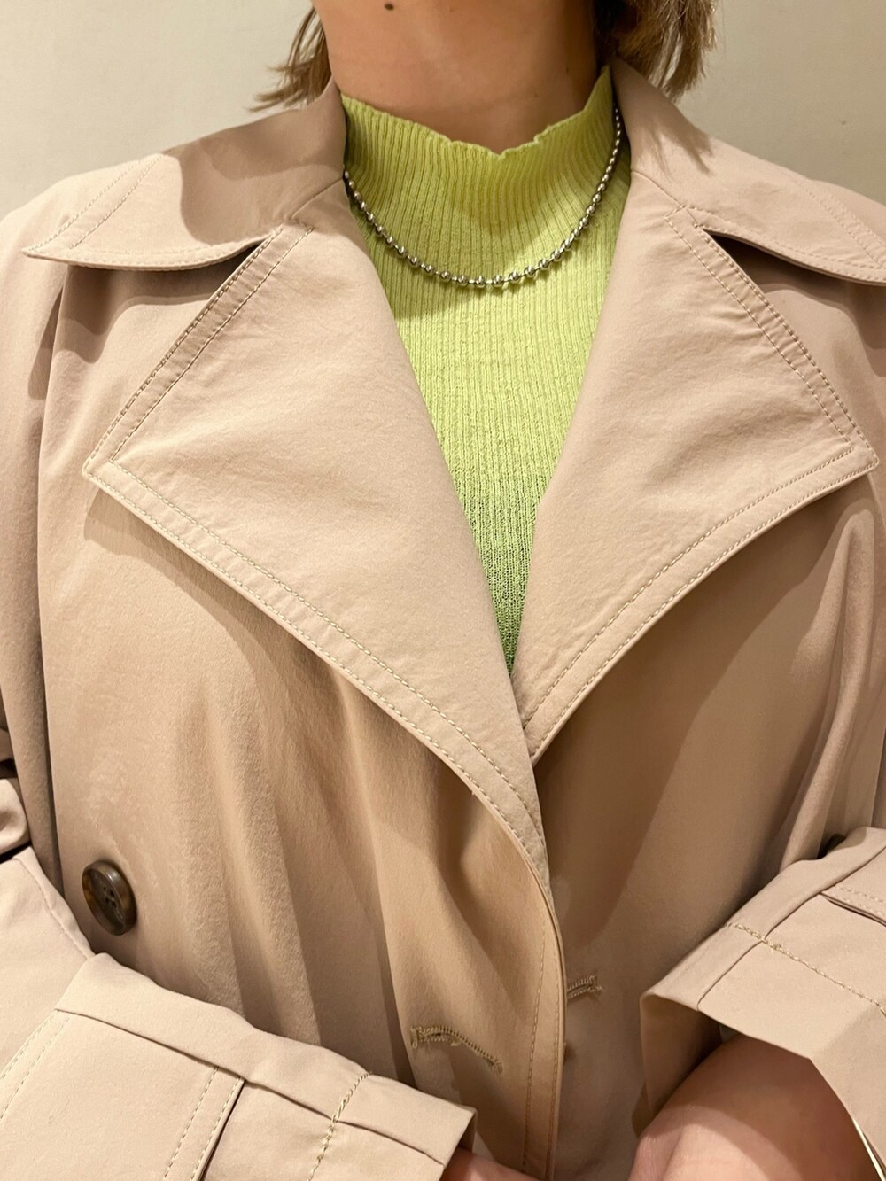 グリーン系のニット/セーター、ベージュ系のトレンチコート、ブルー系のデニムパンツを着用したレディースの冬コーディネートの8枚目の写真