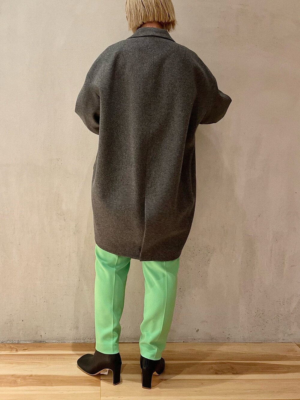 グレー系のチェスターコート、グリーン系のその他パンツ、シルバー系のTシャツ/カットソーを着用したレディースの秋コーディネートの3枚目の写真